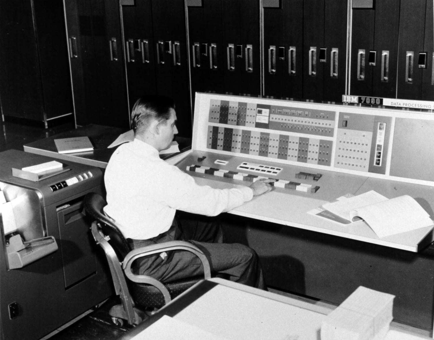 Un météorologue travaille à la console d’un ordinateur IBM 7090