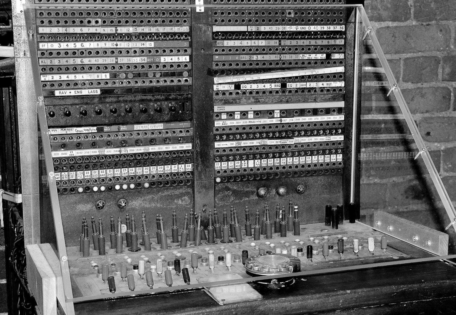 Gros plan sur un tableau de commutation téléphonique à fiches et cordons de connexion colorés, exposé dans un musée.
